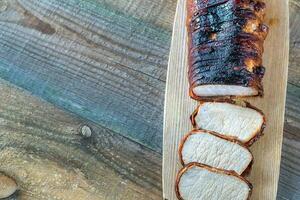 Pork loin wrapped in bacon on the wooden board photo