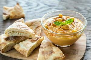 un plato de hummus con rodajas de pita foto