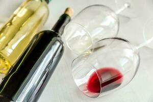 vasos y botellas con vino tinto y blanco foto