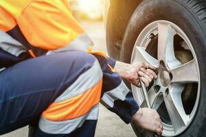 Car wheel replacement. Self-service tire fitting concept. Using a wheel wrench to twist the wheel nuts. photo
