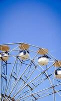 Ferris wheel against blue cloudy sky on sunny weather photo