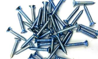 Tapping screws made of steel on Gray background, metal screw, iron screw, chrome screw, screws as a background, wood screw, concept industry. photo