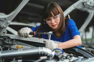 Auto mechanic in garage. Professional auto mechanic who inspects and repairs engine in garage. Car repair and maintenance concept. photo