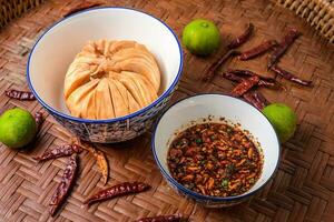 Seasonal food of Thailand. Santol with spicy sauce on the wooden background. photo