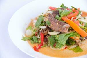 Favorite food of Thailand. Spicy grilled pork salad on the white background. photo