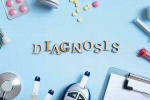 Diagnosis text with stethoscope, syringe, pills and glucometer top view. Healthcare and medicine concept flat lay photo