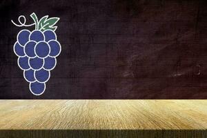 Wood Table with Grapes in Chalk Drawing Style on Grunge Chalkboard Background, Suitable for Product Presentation Backdrop, Display, and Mock up in Wine Concept. photo