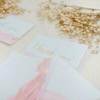 A white card with gold lettering that says thank you on it. photo