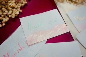 A white card with gold lettering that says thank you on it. photo