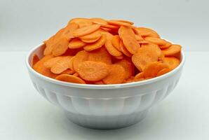 Carrot slice in a bowl isolated on white background photo