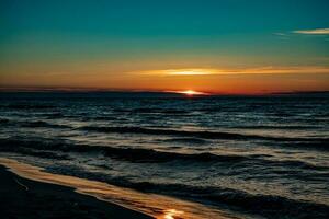 pintoresco calma puesta de sol con vistoso nubes en el costas de el báltico mar en Polonia foto