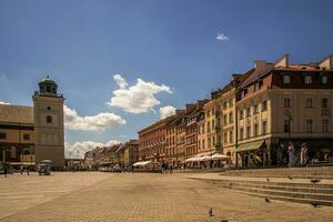 urbano paisaje de el antiguo pueblo de Varsovia en Polonia en un calentar verano día con corriente de agua en el calles de Krakowskie przedmiescie y el zigmut columna foto