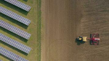 New and Old Farming as a Seed Drill Works Alongside a Solar Power Farm video