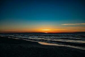 picturesque calm sunset with colorful clouds on the shores of the Baltic Sea in Poland photo