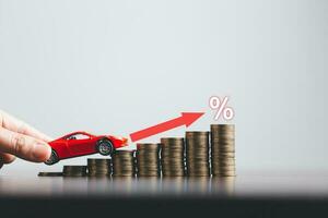 Stacks of coins and red car with percentage symbol for increasing interest rates. Interest rate financial and mortgage rates. Icon percentage symbol and arrow pointing up. photo