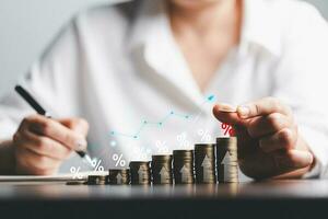 Business woman hand and stack coins money with up arrow and percentage symbol of Interest rate financial and mortgage rates. Icon percentage symbol and arrow pointing up. photo