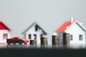 Stacks of coins and model house and car with percentage symbol for increasing interest rates. Interest rate financial and mortgage rates. Icon percentage symbol and arrow pointing up. photo