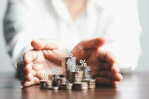 Businesswoman hand giving heap of coins money with up arrow and percentage symbol of Interest rate financial and mortgage rates. Icon percentage symbol and arrow pointing up. photo