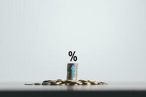 Stacked coins on wooden table with illustration shows increasing of interest rates, financial concept. Interest rate financial and mortgage rates. Icon percentage symbol and arrow pointing up. photo