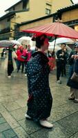 Kyoto, Japan in April 2019. A geisha wearing a kimono walking in the Gion district. photo