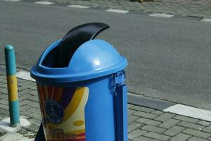 Medan, Indonesia, february 2023 - blue trash can on the side of the road.  empty trash can on the sidewalk.  no trash on the streets.  streets that look clean from trash photo