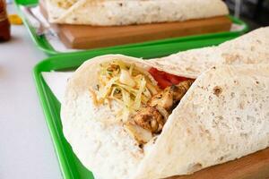 Grilled kebab with pita bread and vegetables on tray in summer fast food street cafe photo