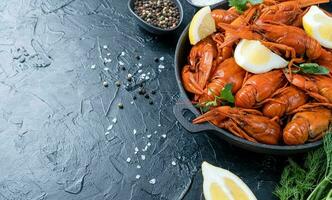 cooked crawfish in black saucepan with lemons and spices on dark background photo