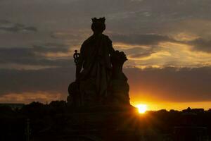 ver en puesta de sol detrás la ville Delaware París estatua en Pont du carrusel en París foto