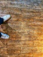 A pair of white shoes on a floor with a wooden texture. photo