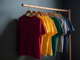 a collection of cotton t-shirts hanging on a hanger , photo