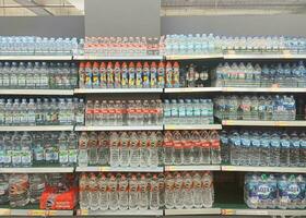 Solo, Indonesia - February, 2023 - mineral water of various brands in the supermarket above the window photo