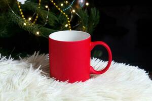 blanco rojo jarra con Navidad árbol en fondo, estera té o café taza con Navidad y nuevo año decoración,horizontal burlarse de arriba con cerámico jarra para caliente bebidas, vacio regalo impresión modelo foto