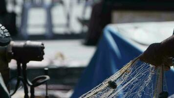 Fisherman is Repairing Fishnets on Fishing Boat in Dock video