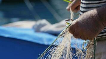 Fisherman is Repairing Fishnets on Fishing Boat in Dock video