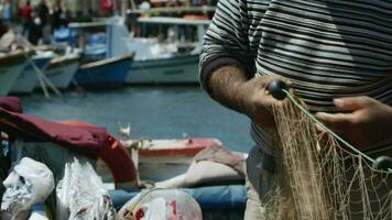 Fisherman is Repairing Fishnets on Fishing Boat in Dock  Video