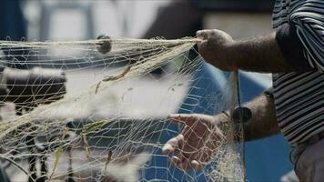 pescatore è riparazione calze a rete su pesca barca nel bacino video