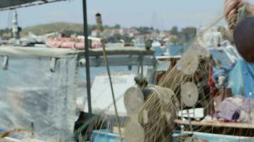 Fisherman is Repairing Fishnets on Fishing Boat in Dock video