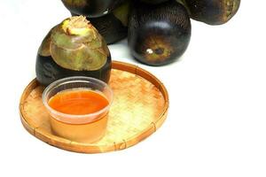 isolated Toddy palm and a jar of Palmyra palm sugar in a bamboo basket suitable for making many desserts such as Toddy palm cake, Toddy Palm Fruit in Syrup. photo