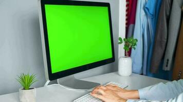 mujer mecanografía en un computadora teclado a hogar oficina, monitor con un verde pantalla. croma llave. Copiar espacio. concepto de remoto trabajar. video