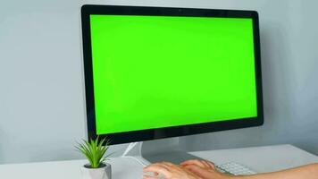 Woman typing on a computer keyboard at home office, monitor with a green screen. Chroma key. Copy Space. Concept of remote work. video