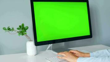 Frau Tippen auf ein Computer Tastatur beim Zuhause Büro, Monitor mit ein Grün Bildschirm. Chroma Taste. Kopieren Raum. Konzept von Fernbedienung arbeiten. video