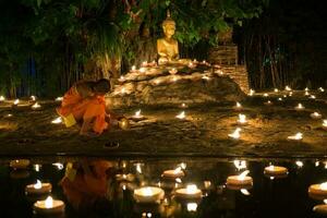 Chiang Mai Thailand, July 22th, 2013, Asaraha Busha day.  Monks are lighting the candles photo