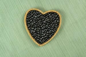 heart shaped black bean bowl on green tablecloth photo