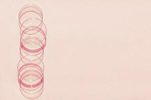 Petri dish. A set of Petri cups. A pipette, glass tube. On a pink background. photo