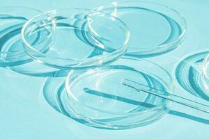 Petri dish. A set of Petri cups. A pipette, glass tube. On a blue blue background. photo