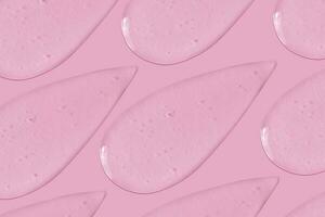 The background is cosmetic. Many smears of transparent gel on a pink background. photo