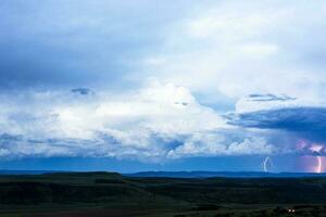 Dark cumulus clouds and lightning after sunset photo