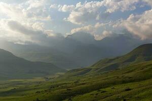 Late afternoon clouds over green valley photo