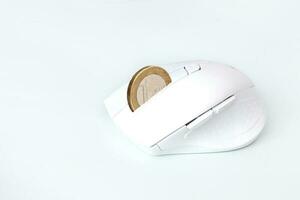 white computer mouse with a coin of 1 euro instead of a wheel, earnings on the Internet photo