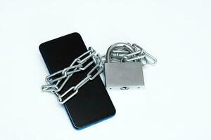 phone in chains and on a padlock on a white background photo